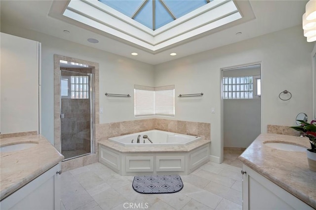 bathroom with vanity, a wealth of natural light, a skylight, and shower with separate bathtub