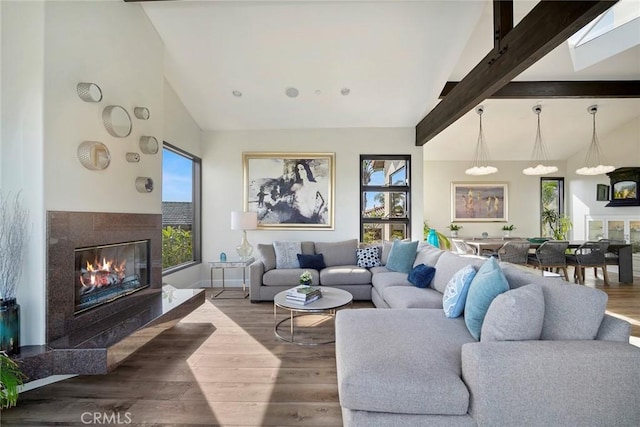 living room with beamed ceiling, a premium fireplace, wood-type flooring, and high vaulted ceiling