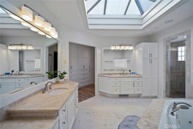 bathroom with vanity, a skylight, and independent shower and bath