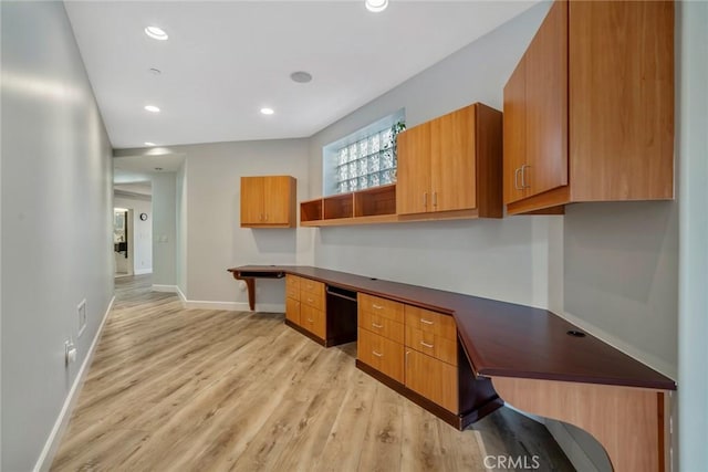 office featuring built in desk and light hardwood / wood-style floors