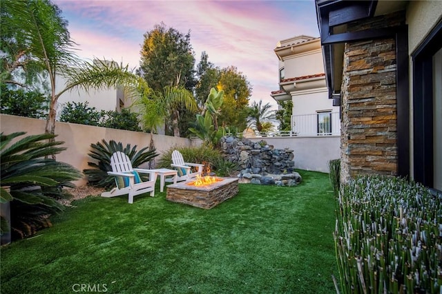 yard at dusk featuring an outdoor fire pit