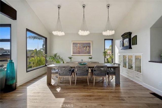 dining area featuring hardwood / wood-style floors and high vaulted ceiling