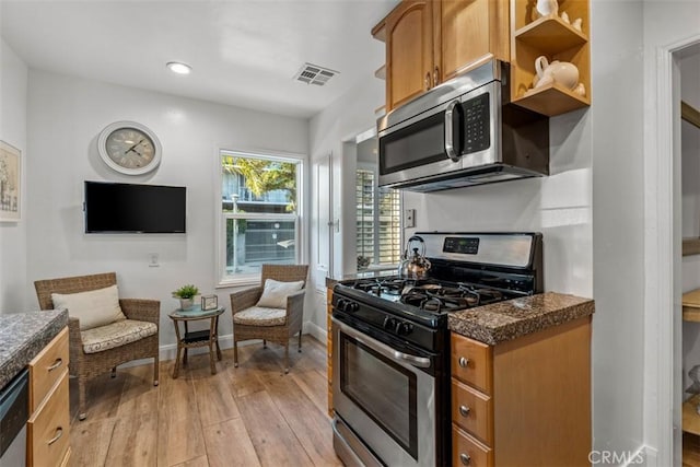 kitchen with appliances with stainless steel finishes and light hardwood / wood-style flooring