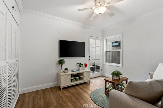 living room featuring hardwood / wood-style floors, crown molding, and ceiling fan