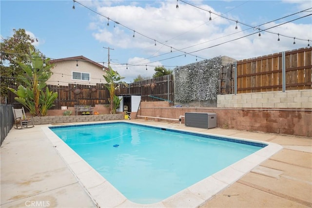 view of swimming pool featuring a patio and central air condition unit