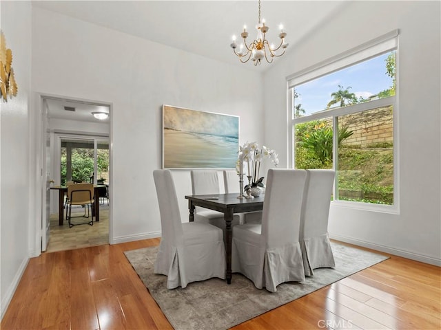 dining space featuring light hardwood / wood-style flooring and a chandelier