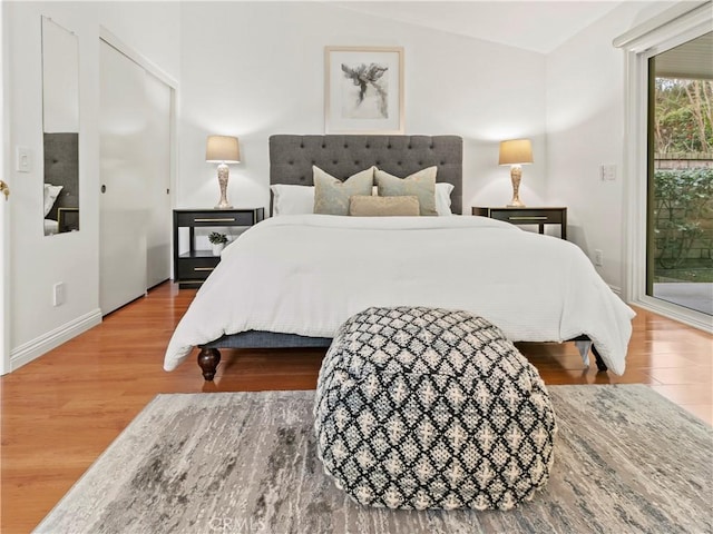 bedroom featuring access to exterior and hardwood / wood-style flooring