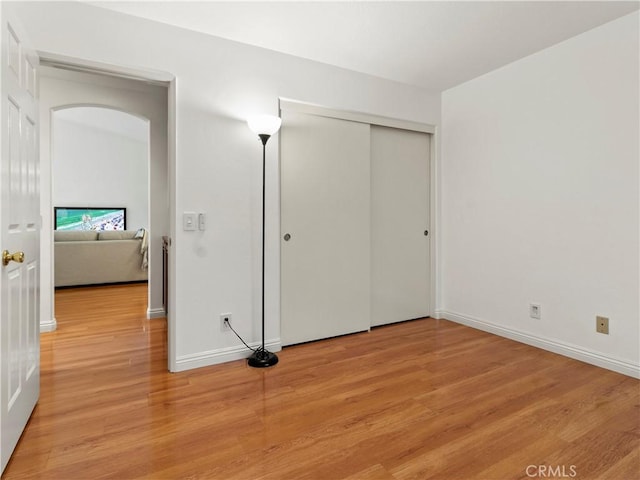 unfurnished bedroom featuring light hardwood / wood-style floors and a closet