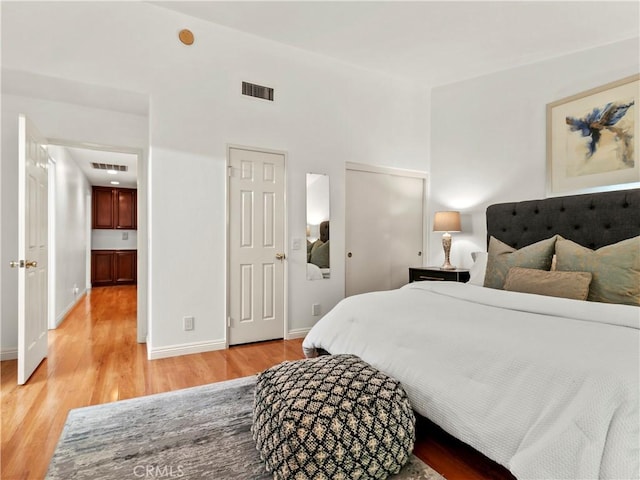 bedroom with two closets and light hardwood / wood-style flooring