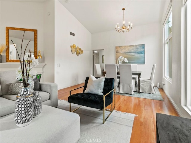 living room featuring a notable chandelier and light hardwood / wood-style flooring