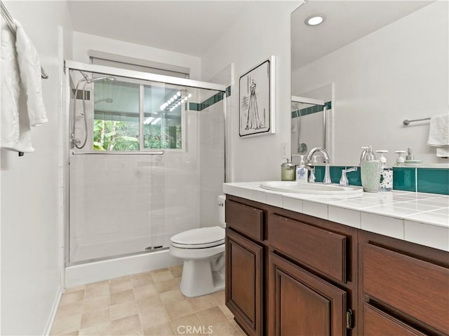 bathroom featuring vanity, a shower with shower door, and toilet