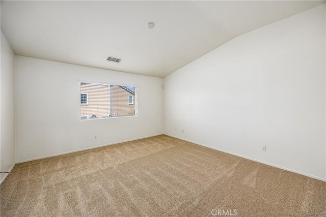 empty room featuring lofted ceiling and light colored carpet