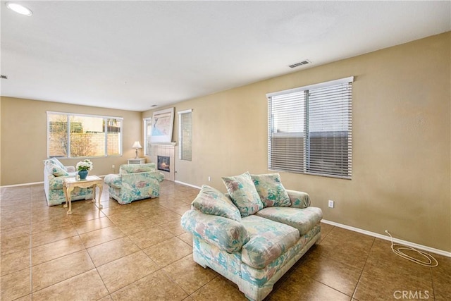 living room with tile patterned floors and a tile fireplace