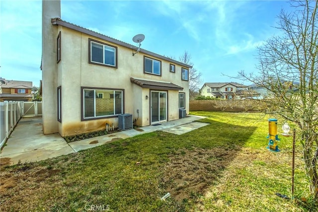 rear view of house with a yard, central AC unit, and a patio area