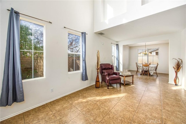 sitting room with a towering ceiling and light tile patterned floors