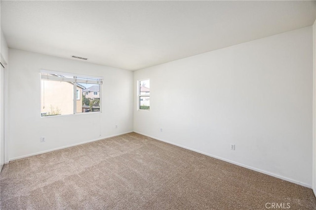 spare room featuring light colored carpet