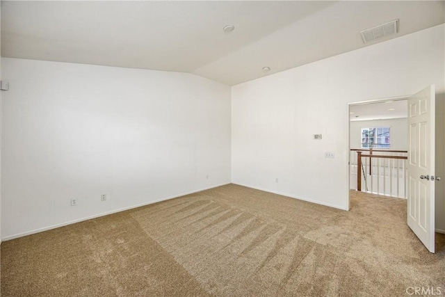 empty room with vaulted ceiling and light carpet