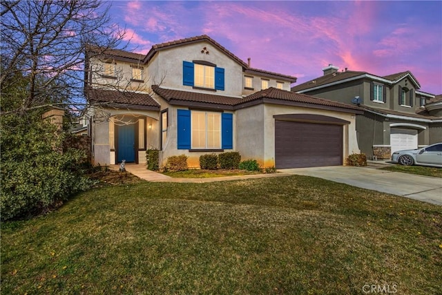 mediterranean / spanish-style home with a garage and a yard