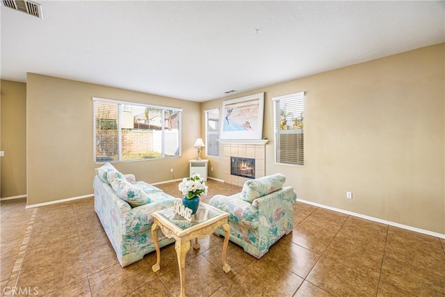 living room featuring a tiled fireplace, a wealth of natural light, and tile patterned floors