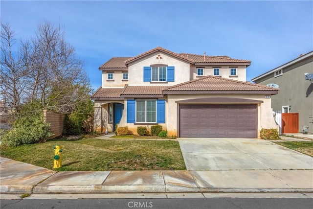 mediterranean / spanish-style house featuring a garage and a front lawn