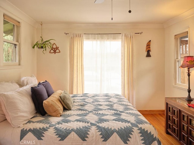 bedroom with crown molding and light hardwood / wood-style floors