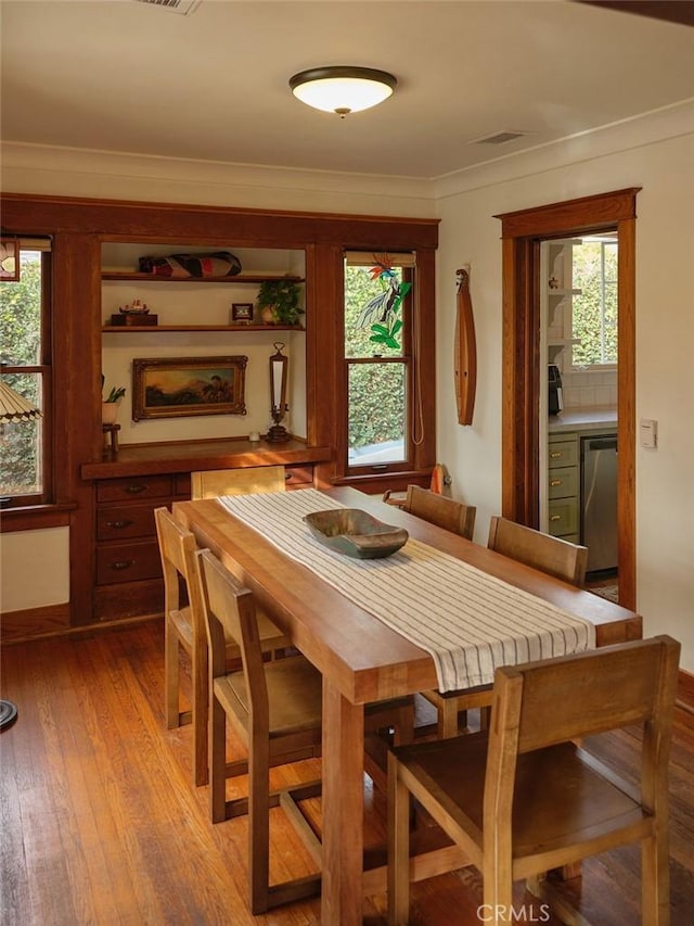 dining space featuring crown molding, light hardwood / wood-style floors, and a wealth of natural light