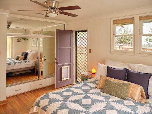 bedroom with crown molding, light hardwood / wood-style flooring, and ceiling fan