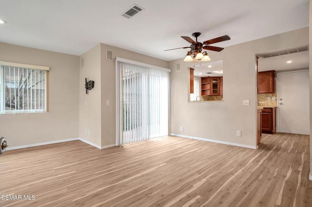 unfurnished living room featuring ceiling fan and light wood-type flooring