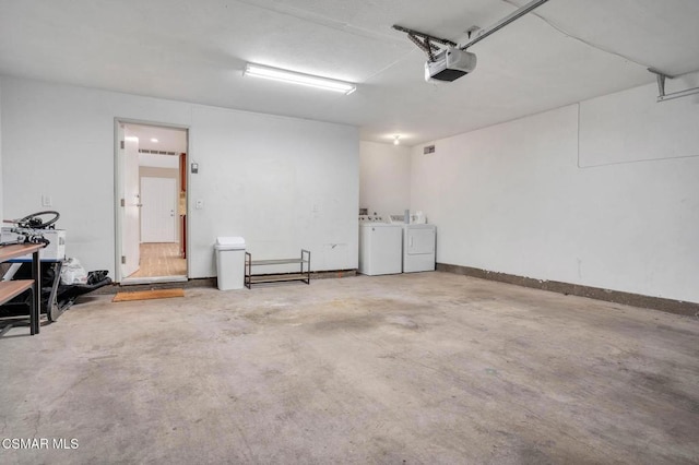 garage with a garage door opener and independent washer and dryer