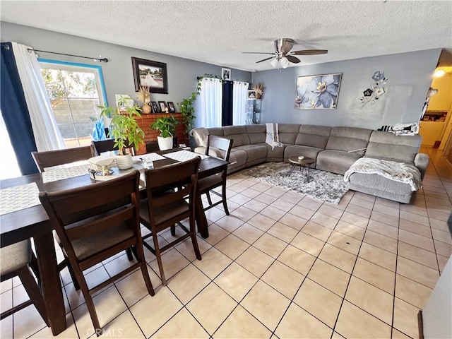 dining space with ceiling fan, a textured ceiling, and light tile patterned floors