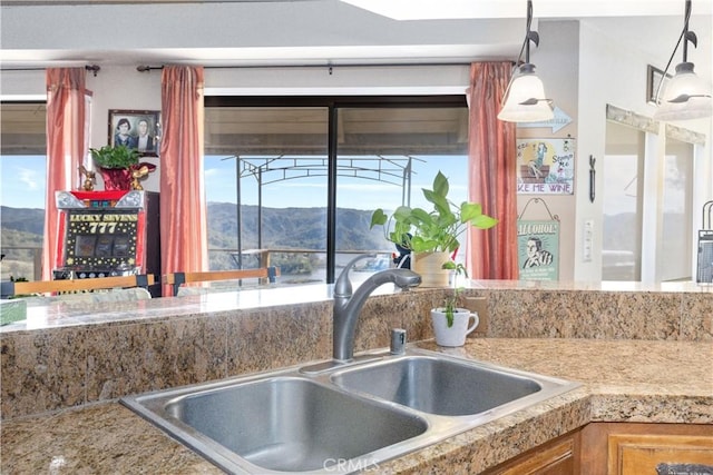 kitchen featuring a mountain view, sink, and pendant lighting