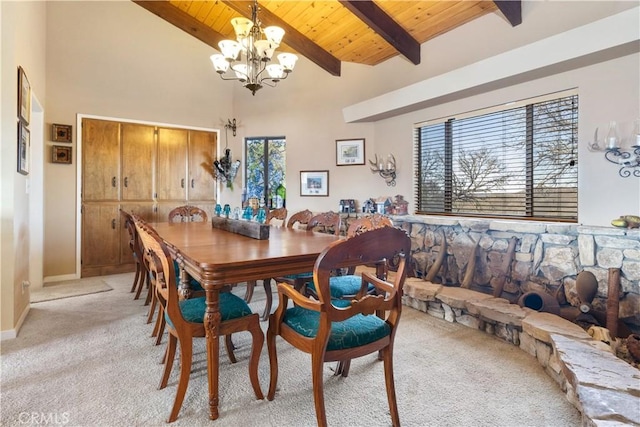 carpeted dining area featuring beamed ceiling, a notable chandelier, a wealth of natural light, and wooden ceiling