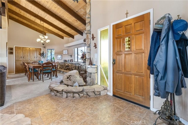 entryway featuring beamed ceiling, an inviting chandelier, wood ceiling, and high vaulted ceiling