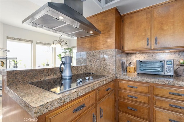 kitchen featuring island range hood, stovetop, and decorative backsplash