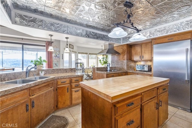 kitchen with stainless steel built in refrigerator, sink, a center island, island exhaust hood, and black electric stovetop