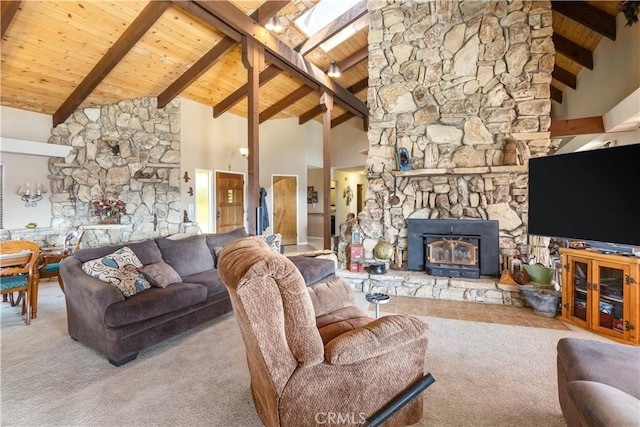 carpeted living room featuring a stone fireplace, high vaulted ceiling, a skylight, beamed ceiling, and wood ceiling