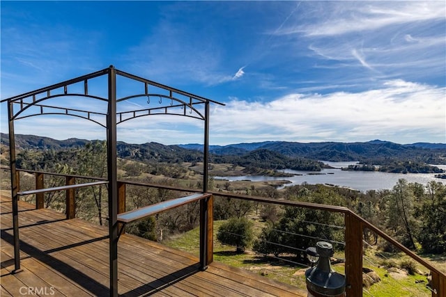 wooden deck with a water and mountain view