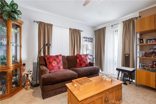 carpeted living room with ceiling fan