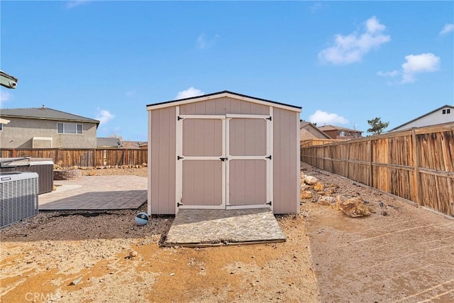 view of shed featuring a fenced backyard and central AC unit