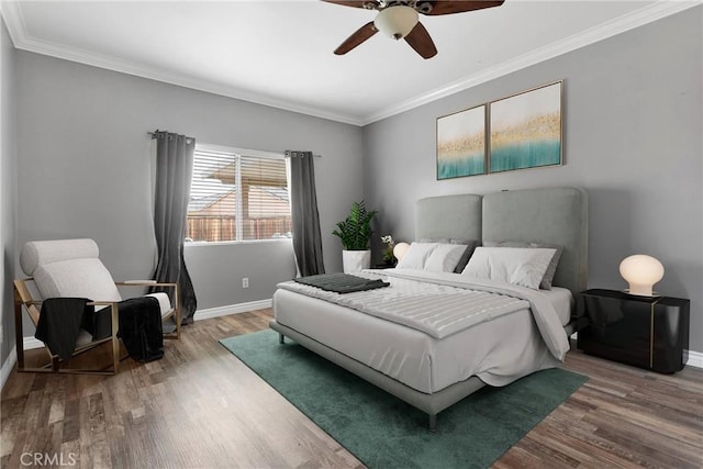 bedroom with ceiling fan, wood finished floors, baseboards, and ornamental molding