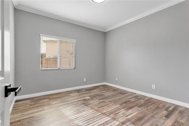 spare room with wood-type flooring and ornamental molding