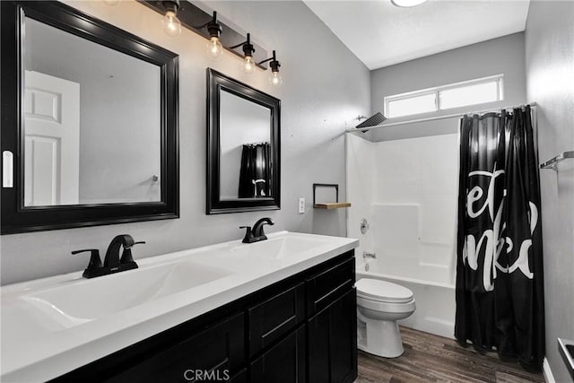 full bath featuring a sink, double vanity, toilet, shower / bath combo with shower curtain, and wood finished floors