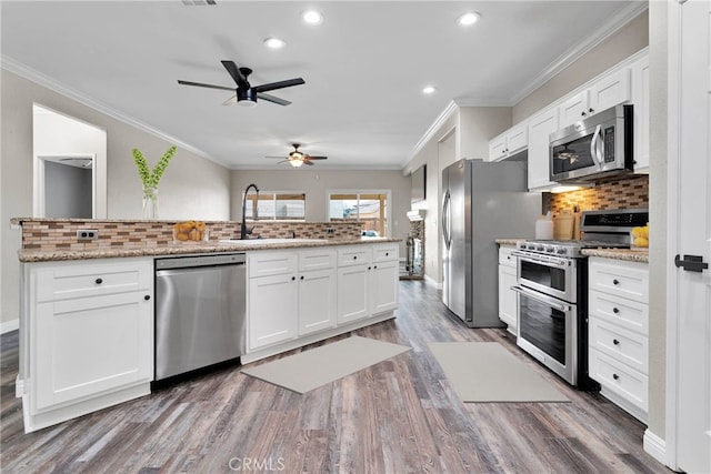 kitchen featuring appliances with stainless steel finishes, white cabinetry, and a sink