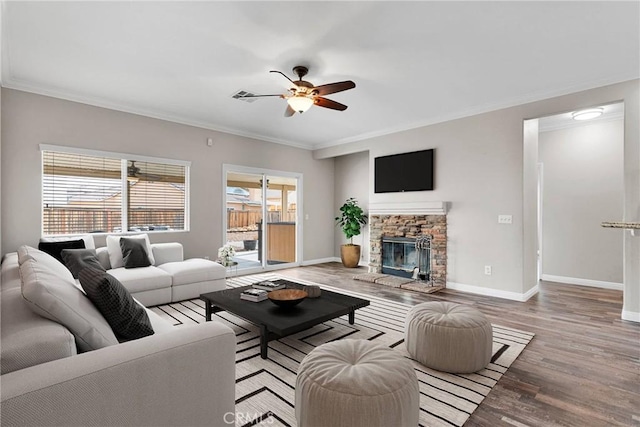 living room featuring ornamental molding, a fireplace, and light hardwood / wood-style floors