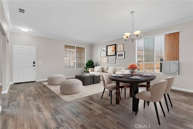 dining room featuring crown molding, dark wood-type flooring, and a notable chandelier