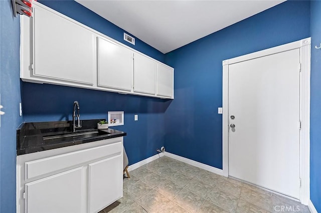 laundry room with sink, hookup for a washing machine, and cabinets