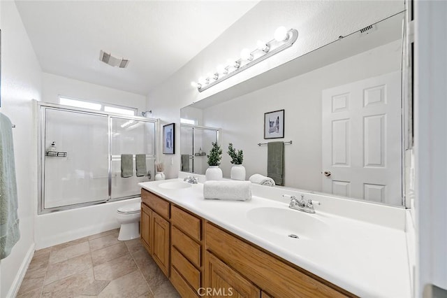 full bathroom featuring enclosed tub / shower combo, vanity, tile patterned floors, and toilet