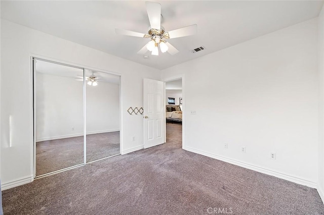 unfurnished bedroom featuring a closet, ceiling fan, and dark colored carpet