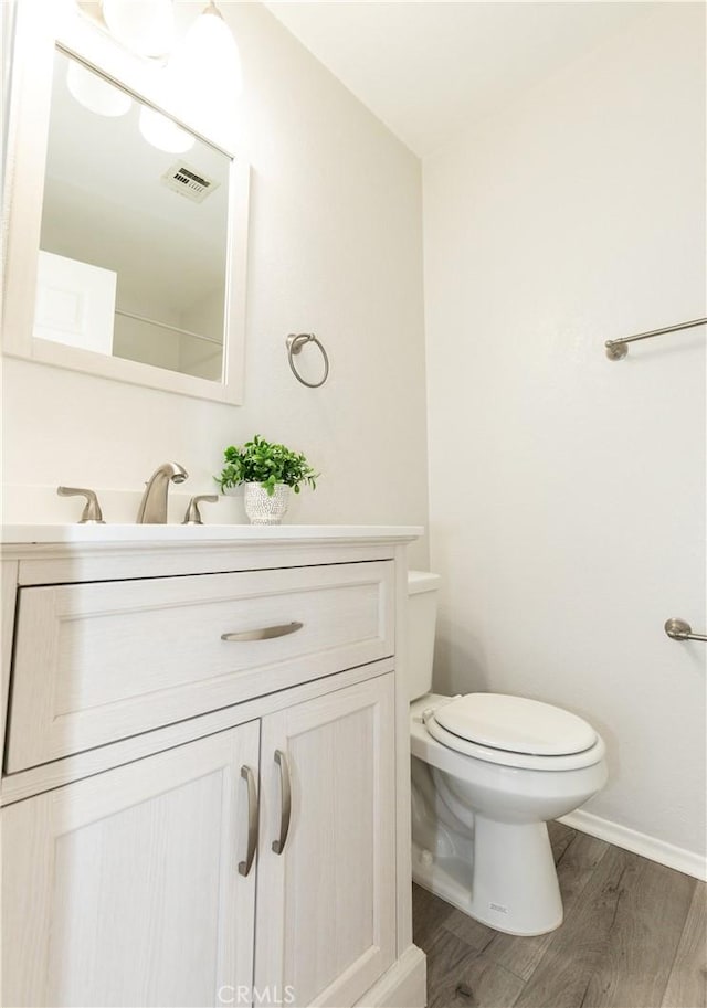 bathroom featuring vanity, hardwood / wood-style floors, and toilet