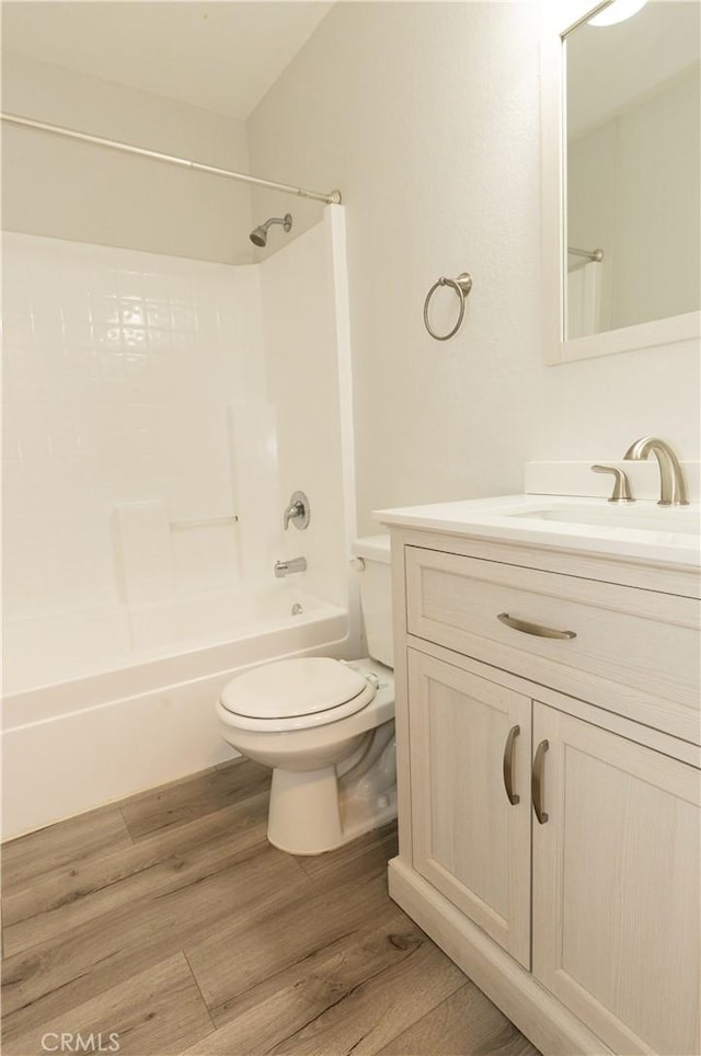 full bathroom featuring shower / bathing tub combination, vanity, wood-type flooring, and toilet